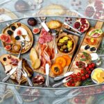 A complete 38-piece Raiten silver charcuterie board utensil set, including various cheese knives, small serving bowls, tongs,