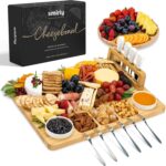 SMIRLY large bamboo charcuterie board set with cheese knives, ceramic bowls, and fruit tray, beautifully arranged with food.