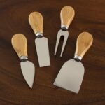 A four-piece Totally Bamboo cheese tool set with brown bamboo handles and silver stainless steel blades, arranged on a surfac